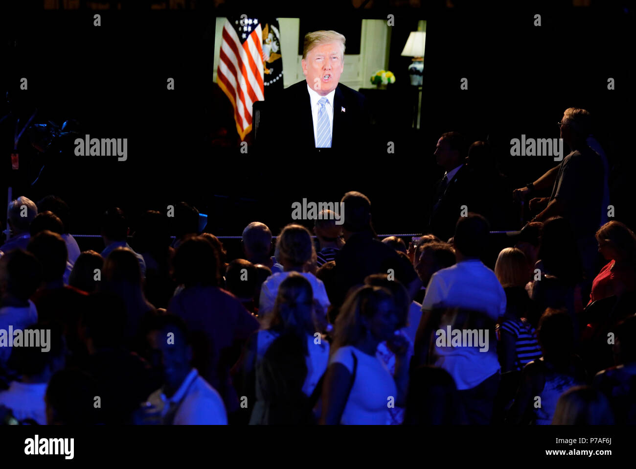 Guests watch U.S. President Donald Trump's address of the South Lawn of the White House before a fireworks display in Washington, DC, U.S., on Wednesday, July 4, 2018. Trump's campaign won the technical knockout of a lawsuit filed by two Democratic National Committee donors and a DNC staffer who accused it of colluding with Russian to publish compromising information about the Clinton campaign on WikiLeaks that included details about their lives. Credit: Yuri Gripas/Pool via CNP /MediaPunch Stock Photo