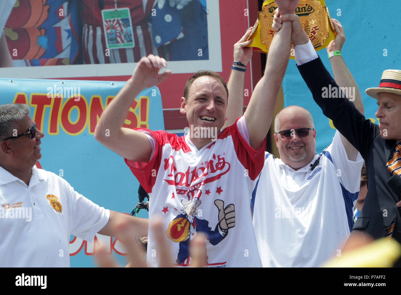 New York, NY, USA. 4th July, 2018. (L-R) Brooklyn Attorney General Eric Gonzalez, Professional Eater Joey Chestnutt (Winner) and MC George Shea attend the New York City 4th of July Annual Nathan's Hot Dog Competition held at Nathan's Coney Island on July 4, 2018 in Coney Island, New York City. Credit: Mpi43/Media Punch/Alamy Live News Stock Photo