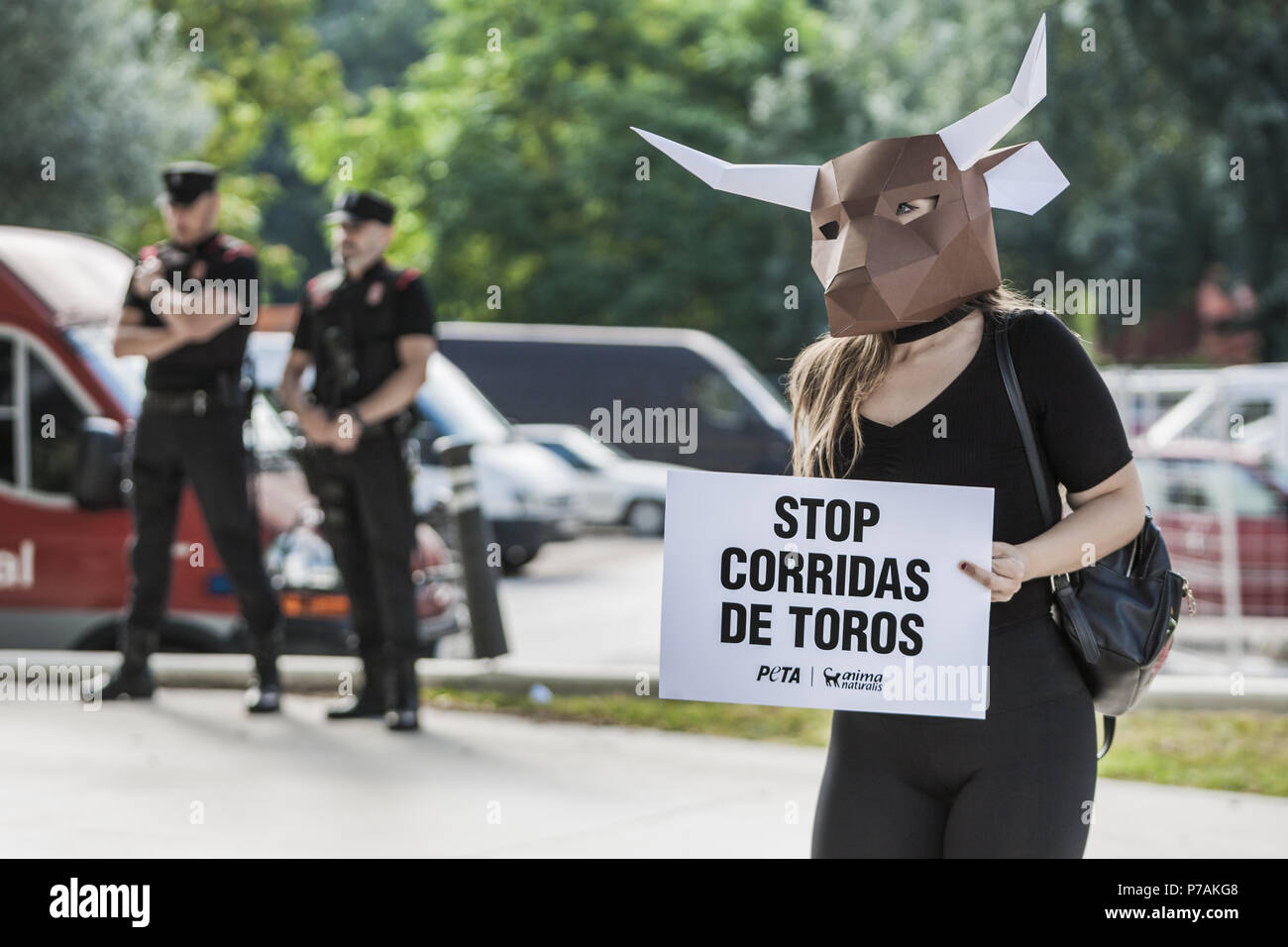 Pamplona, Navarra, Spain. 5th July, 2018. Activist against animal cruelty in bull fightings wears a paperboard bullhead mask near the local police before the San Fermin celebrations, Spain. Banner says ''stop bullfightings' Credit: Celestino Arce/ZUMA Wire/Alamy Live News Stock Photo