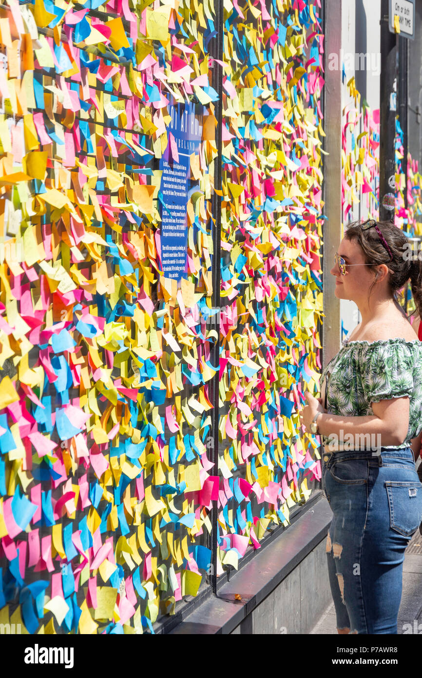 Young woman looking at wall covered in post-it notes (abortion referendum support), Temple Bar, Dublin, Leinster Province, Republic of Ireland Stock Photo