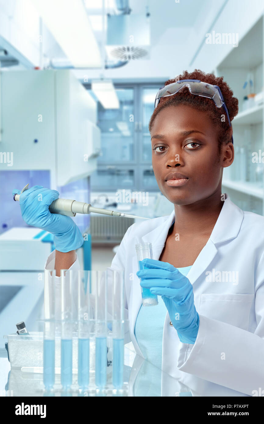 Africanamerican scientist or graduate student in lab coat and protective wear works in modernl