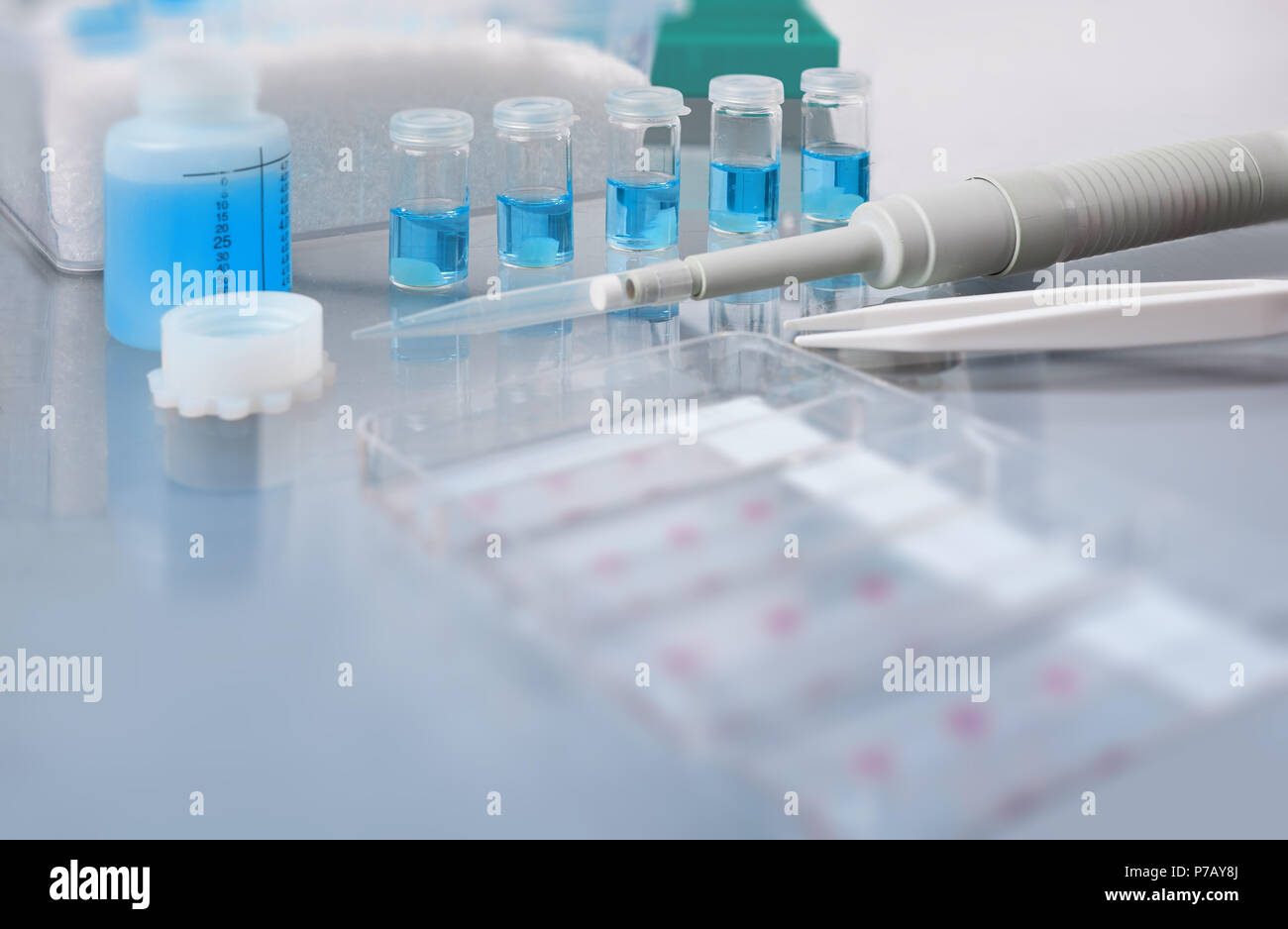 Blurred background for histopathology-related presentation. Stained histological tissue samples on glass, fixed tissue, automatic pipette and other wo Stock Photo