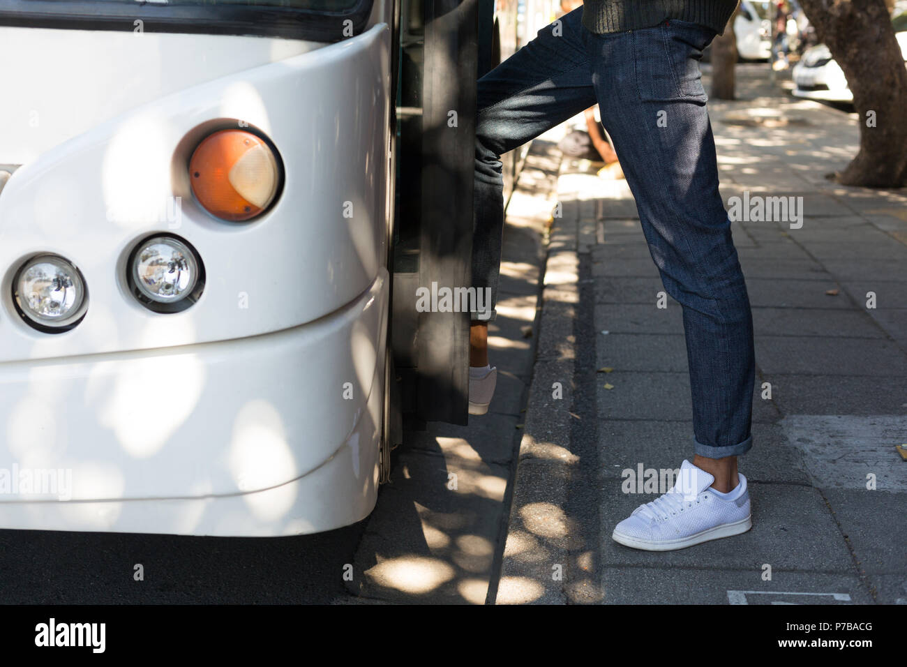 Low section of man boarding bus Stock Photo