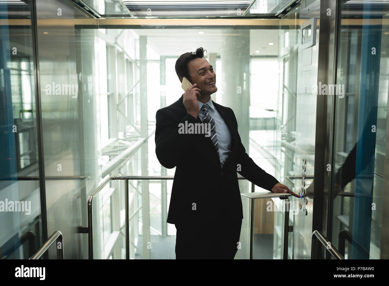 Businessman talking on the phone in elevator Stock Photo