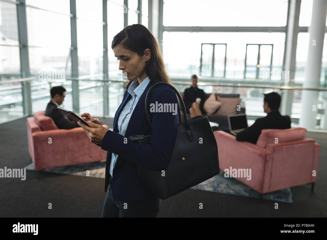 Businesswoman using her mobile phone in office Stock Photo