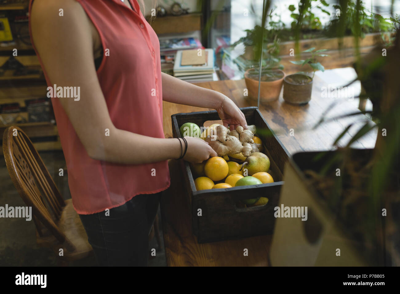 Young woman removing vegetable from the tray Stock Photo