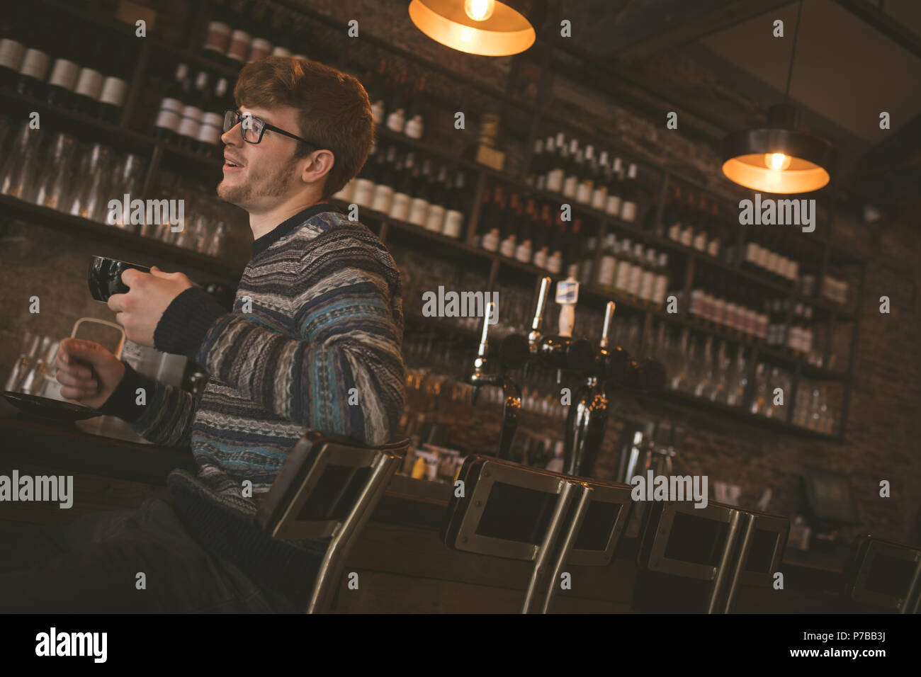 Man having coffee while sitting at the bar counter Stock Photo