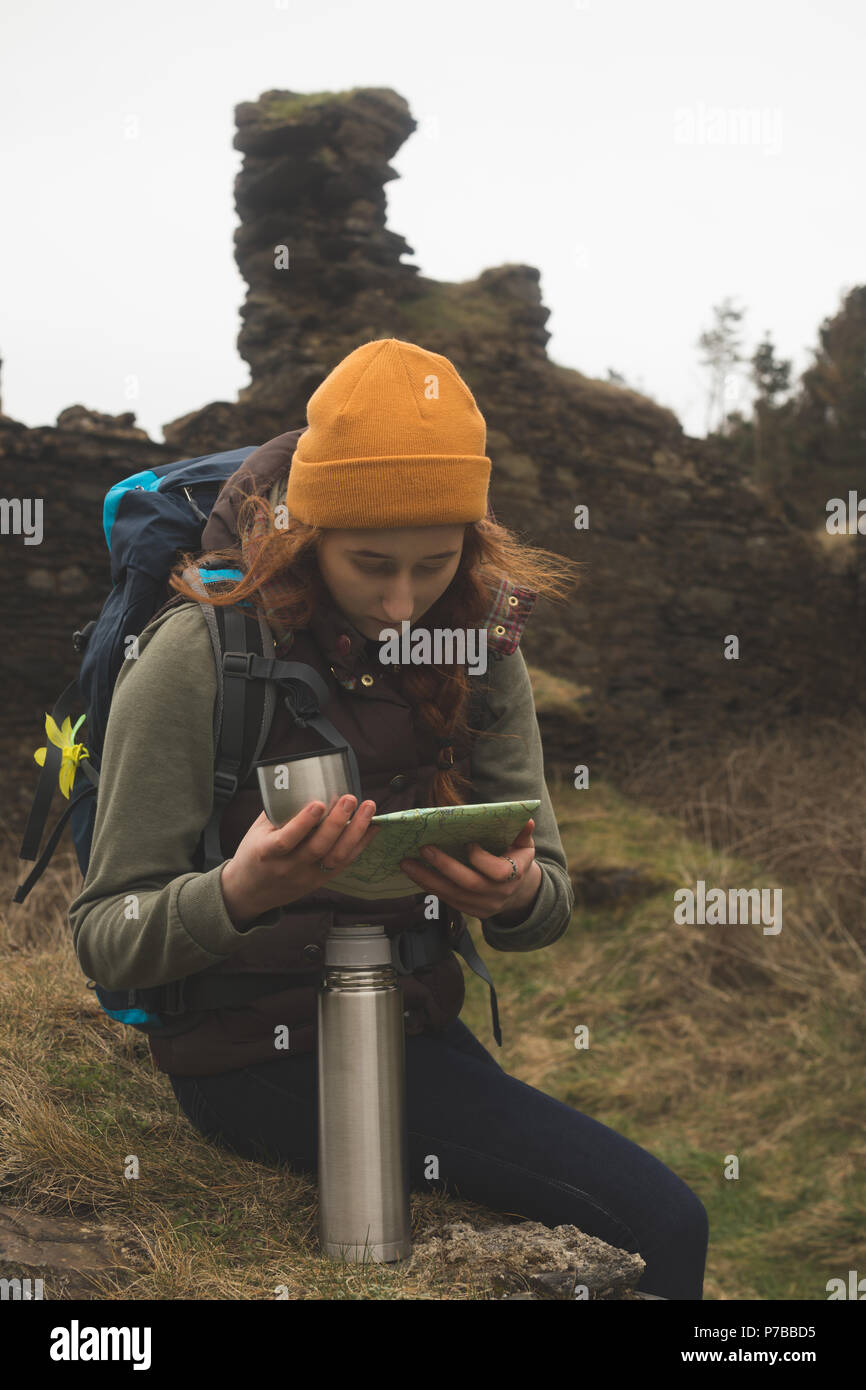 Female hiker reading a map and having a drink Stock Photo