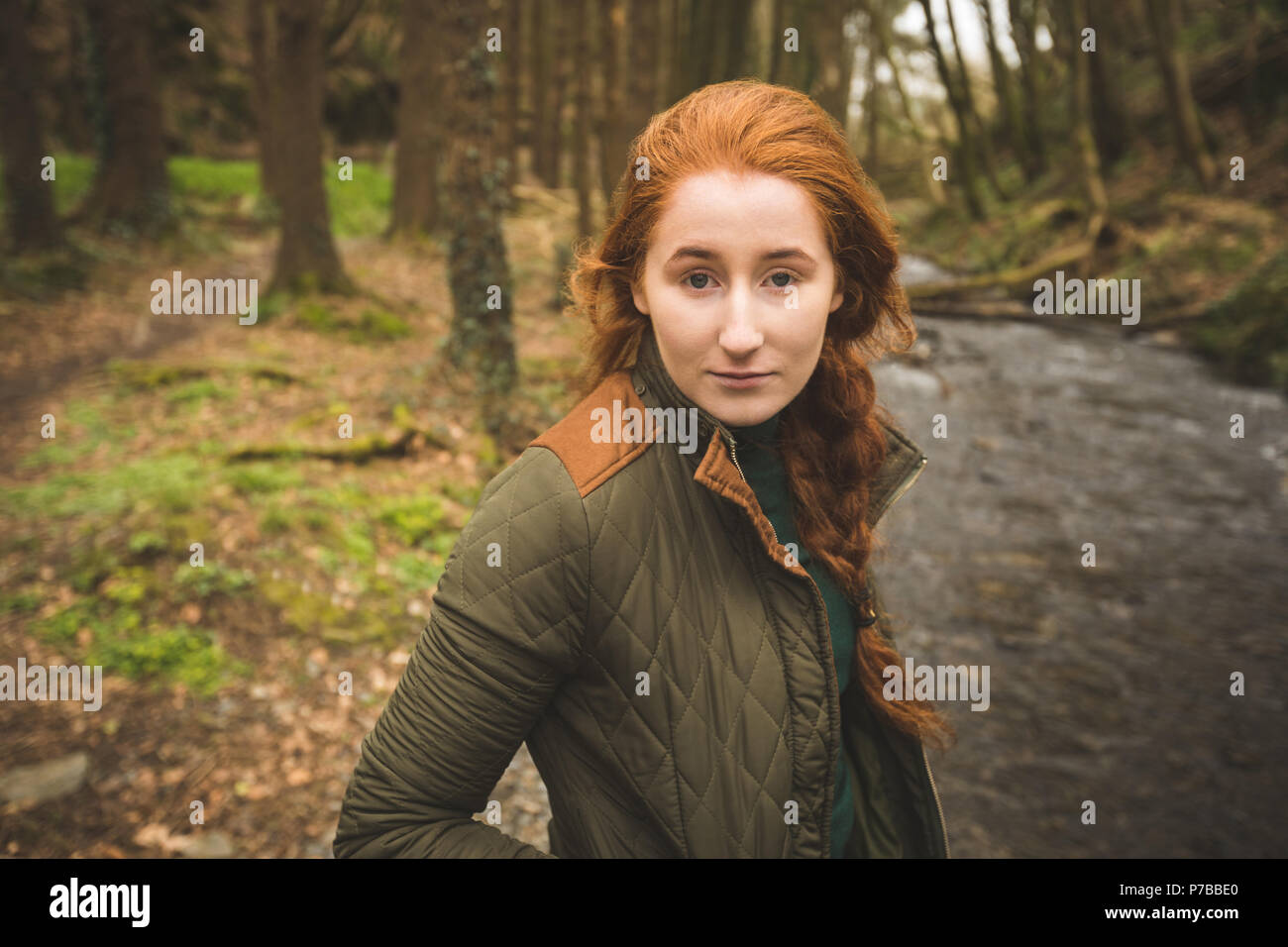 Young female hiker standing near the river coast Stock Photo