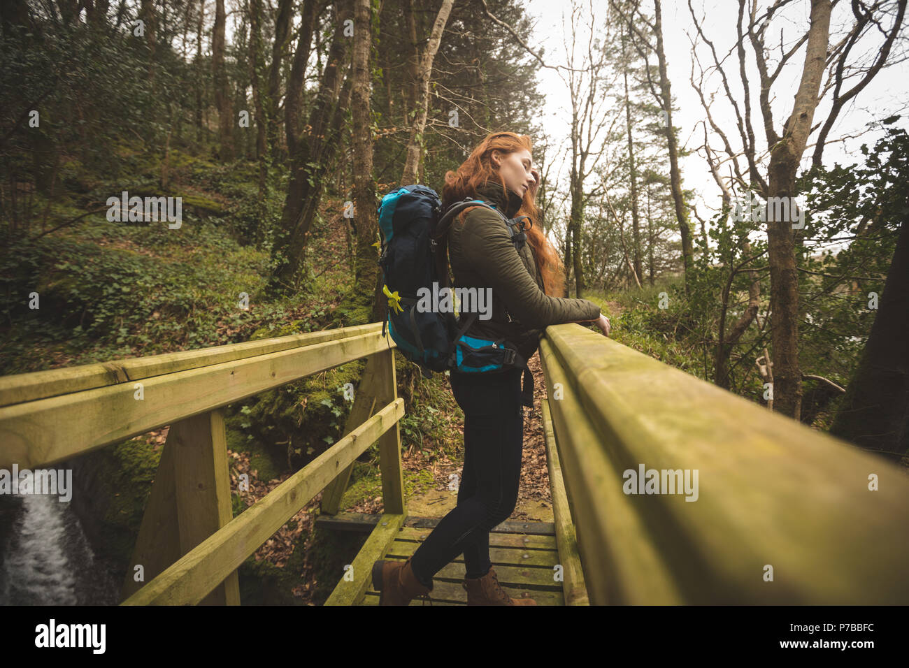 Female hiker with backpack looking around in the forest Stock Photo - Alamy