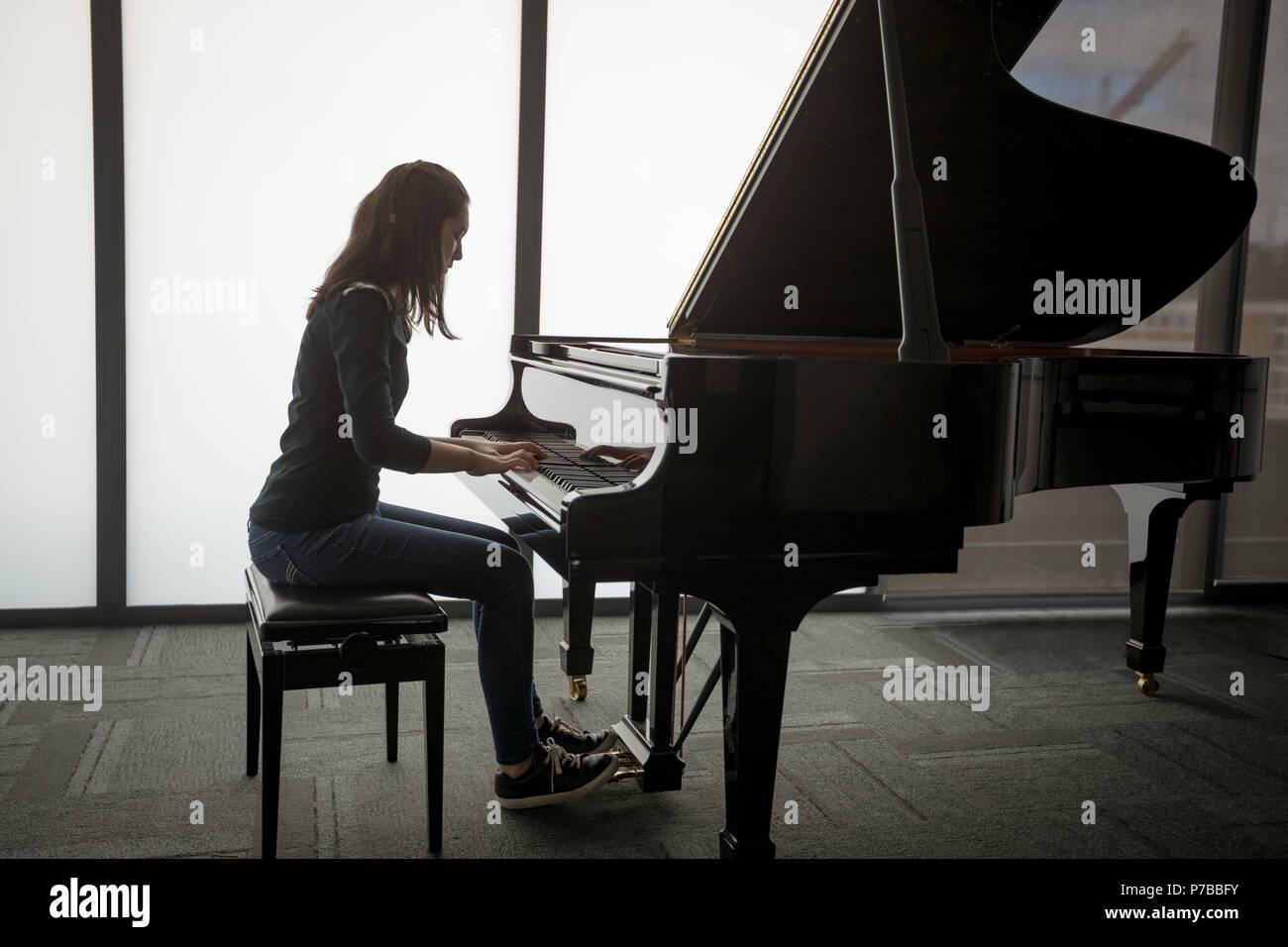 Schoolgirl playing piano in music school Stock Photo
