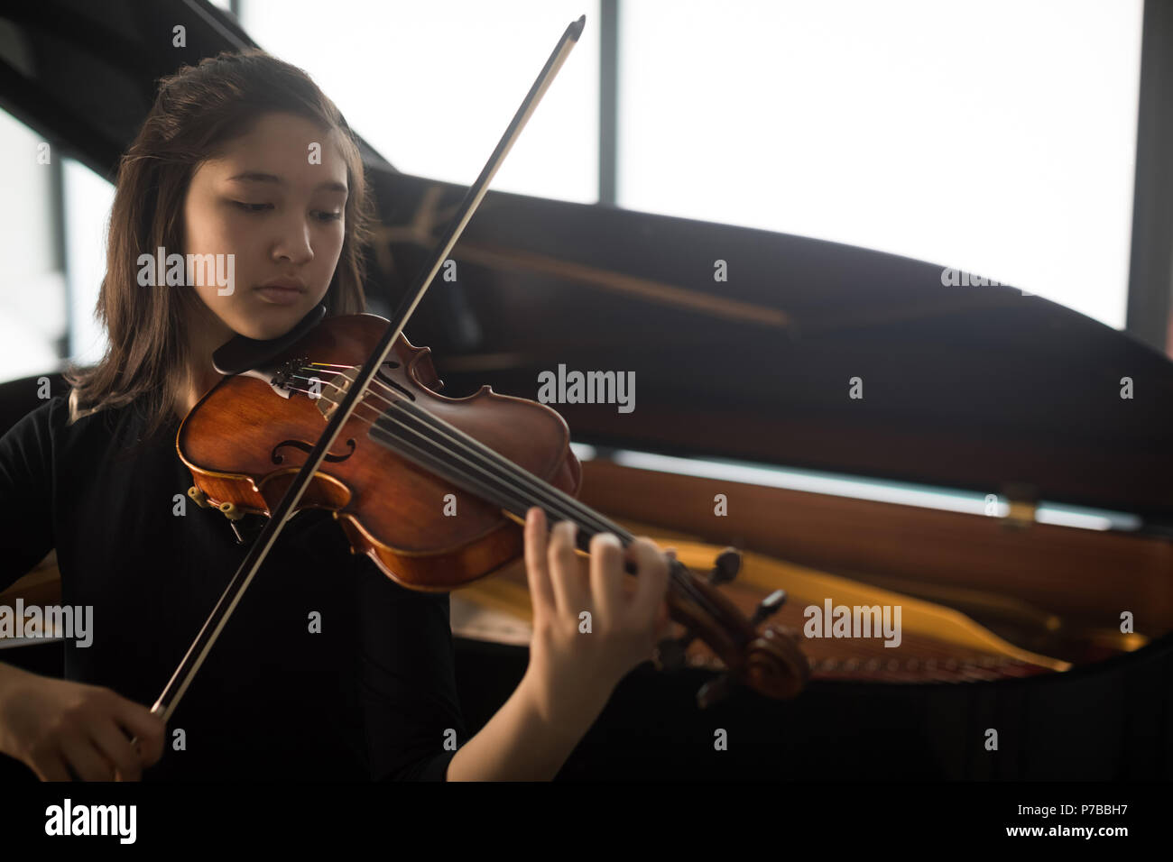 Schoolgirl playing violin in music school Stock Photo