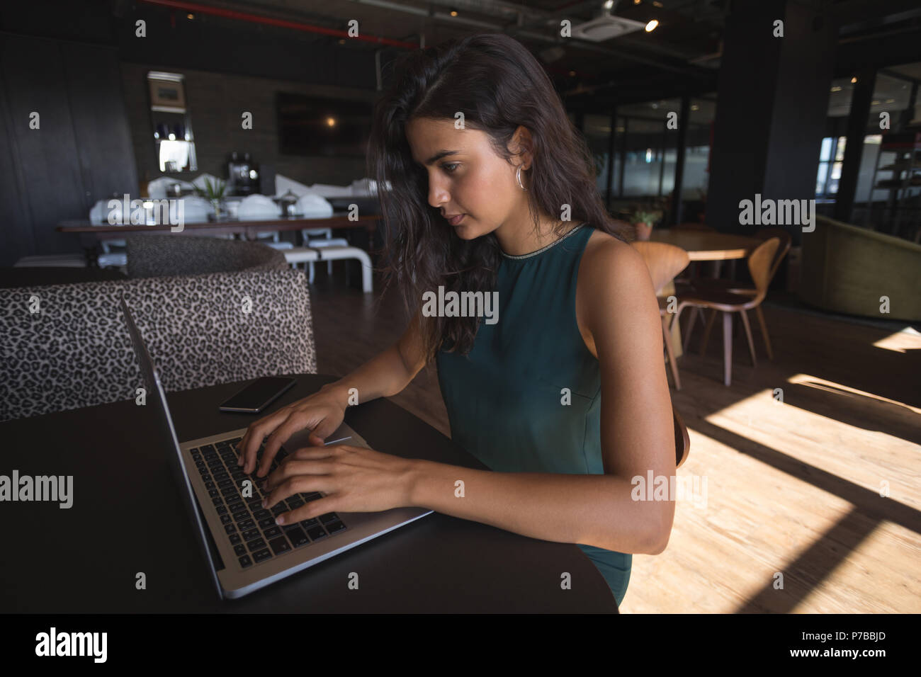 Businesswoman using laptop at office cafeteria Stock Photo