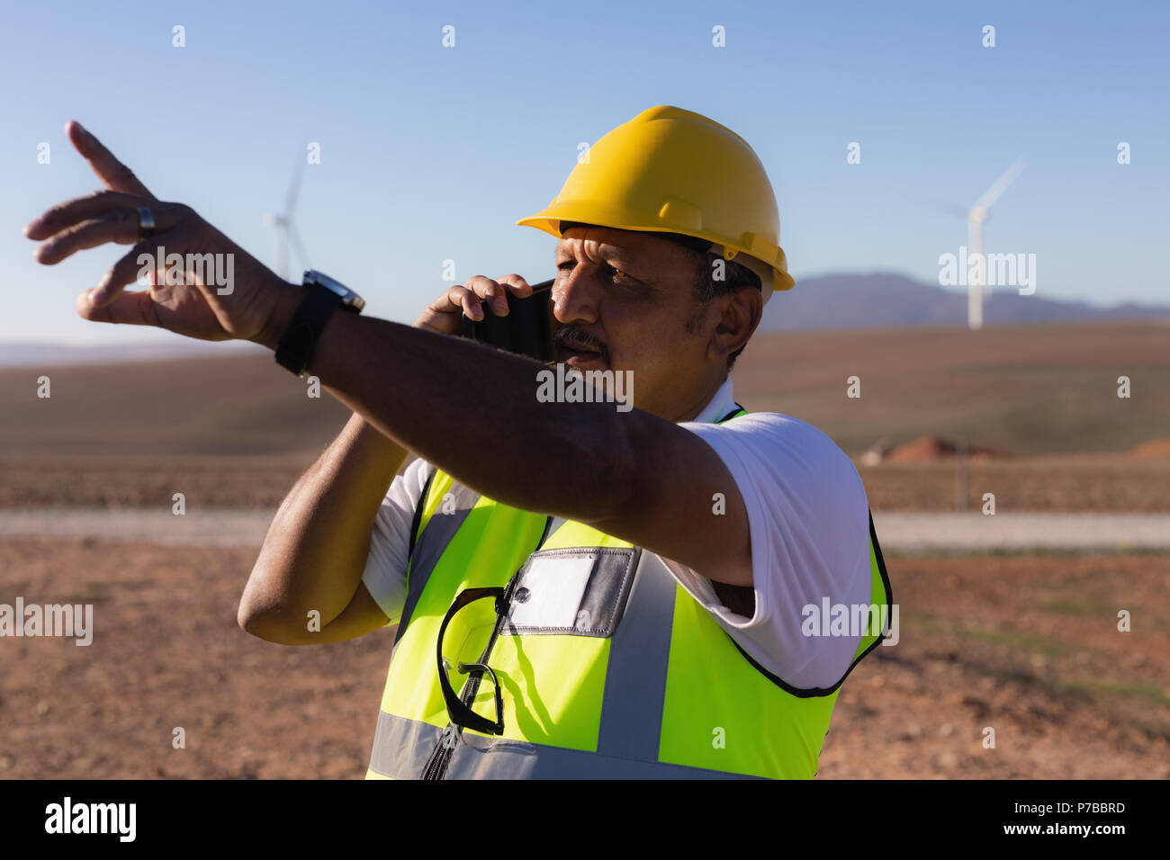 Engineer talking on mobile phone at wind farm Stock Photo