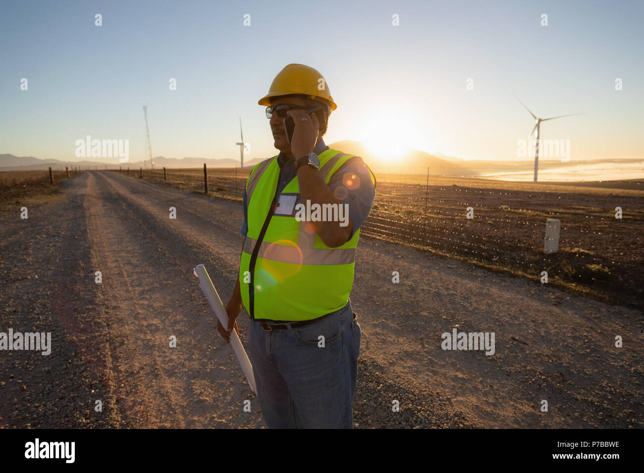 Engineer talking on mobile phone at wind farm Stock Photo