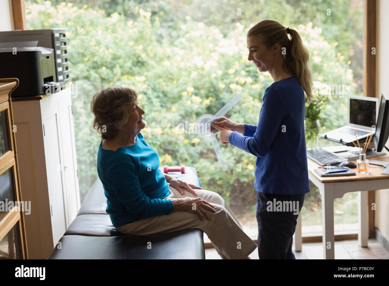 Physiotherapist showing goniometer reading to senior woman Stock Photo