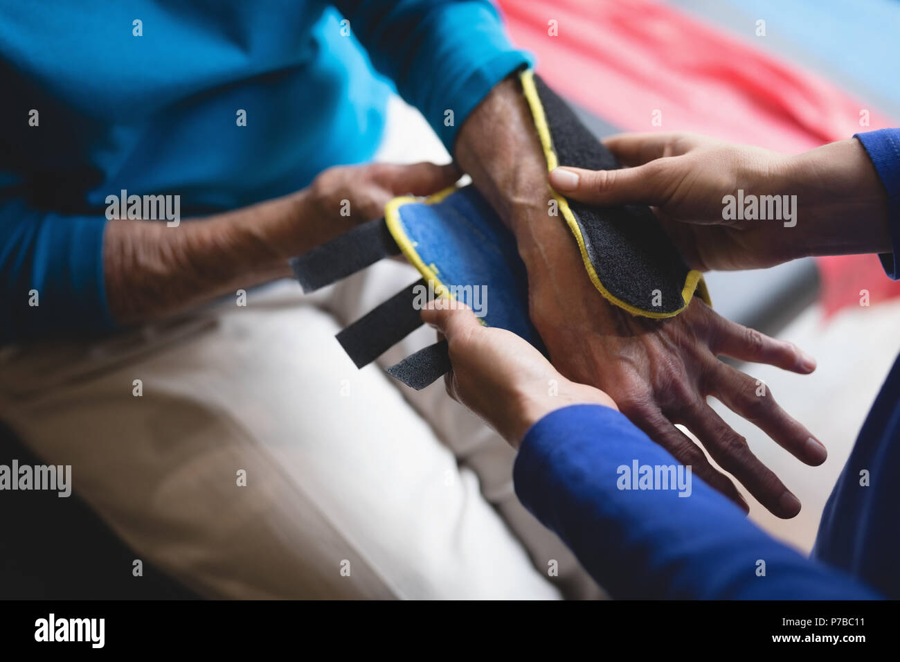 Physiotherapist putting on a wrist support brace on senior woman Stock Photo