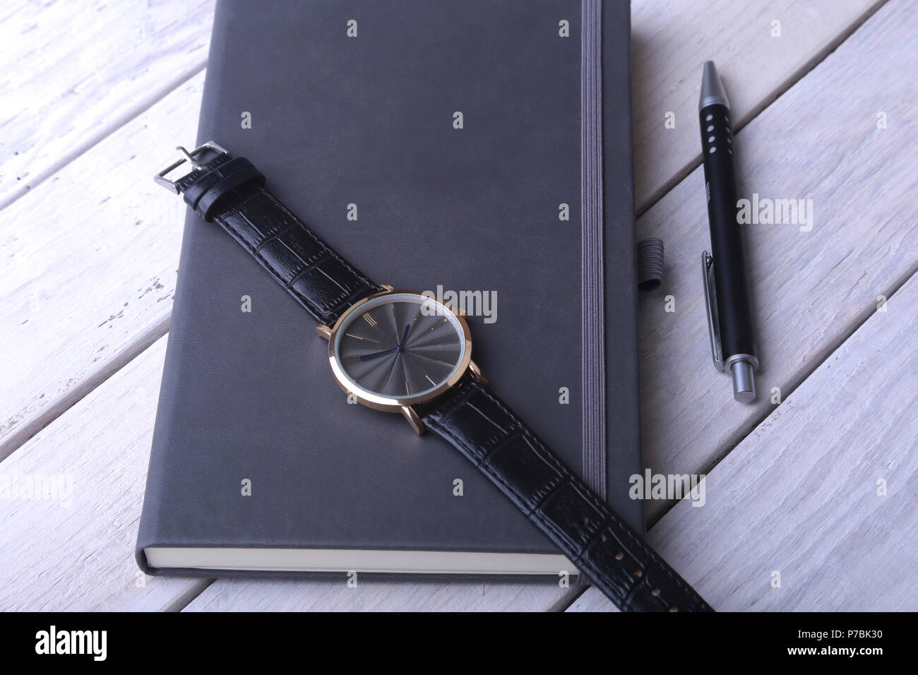 Men's accessories for business and rekreation. Leather notebook, watch and pen on wood background.. Top view composition. Stock Photo