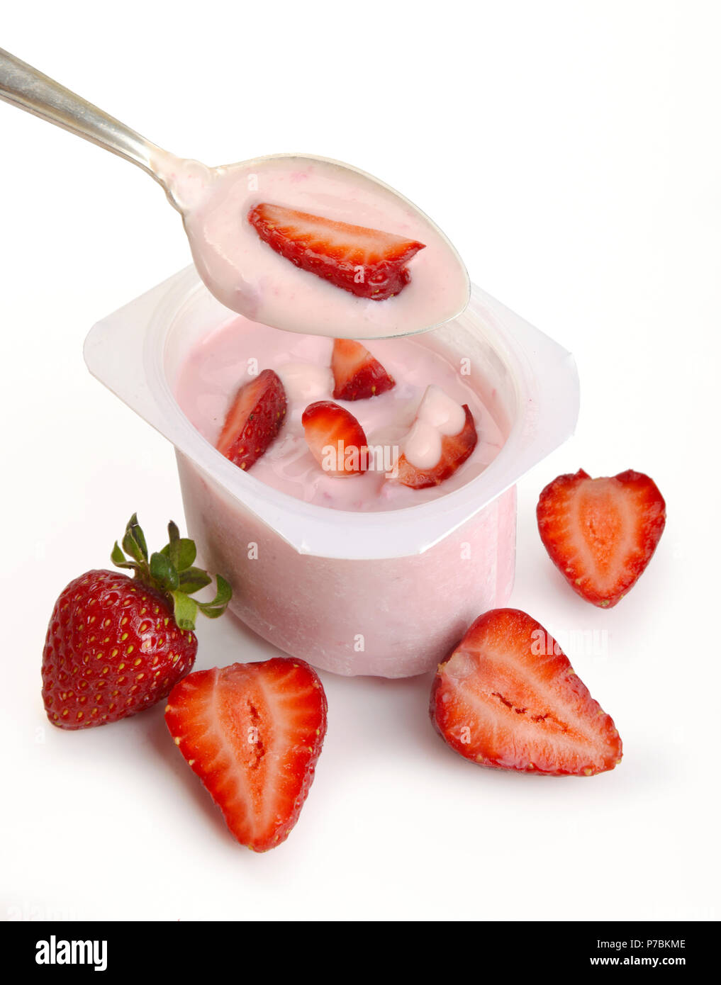 Spoon of yogurt with strawberry on top isolated on white Stock Photo