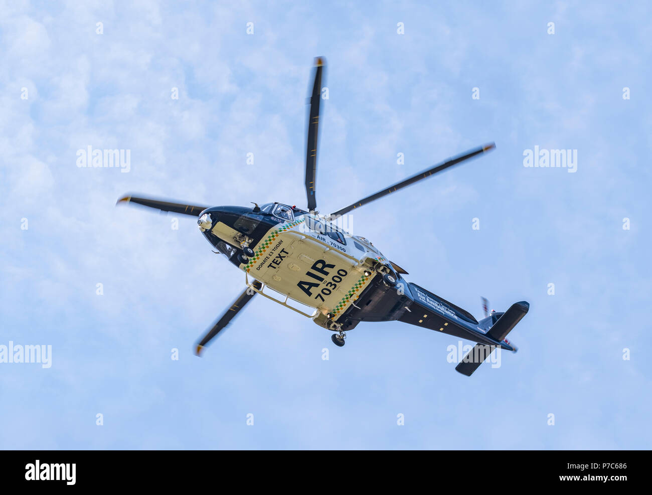 Underside of low flying Kent, Surrey & Sussex air ambulance helicopter (G-KSST) in West Sussex, England, UK. Aircraft is AgustaWestland AW169. Stock Photo