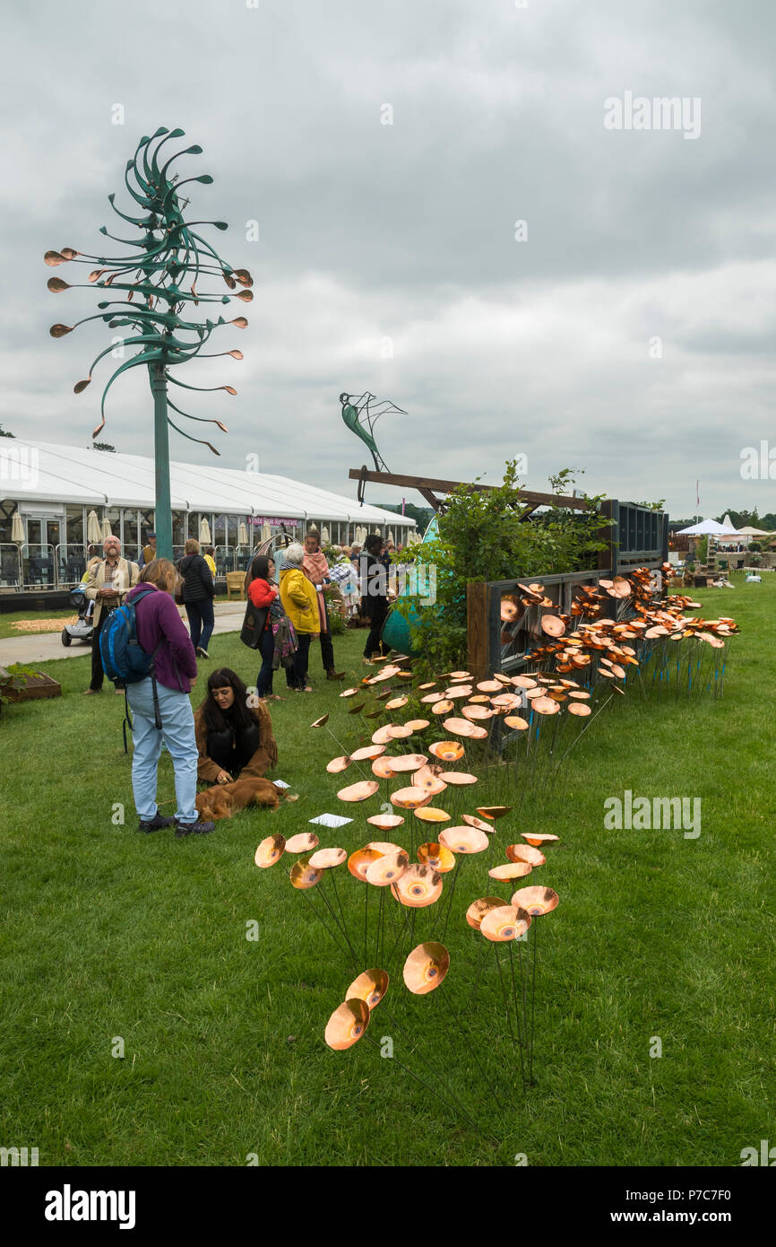 People Standing Looking At Display Of Copper Poppies