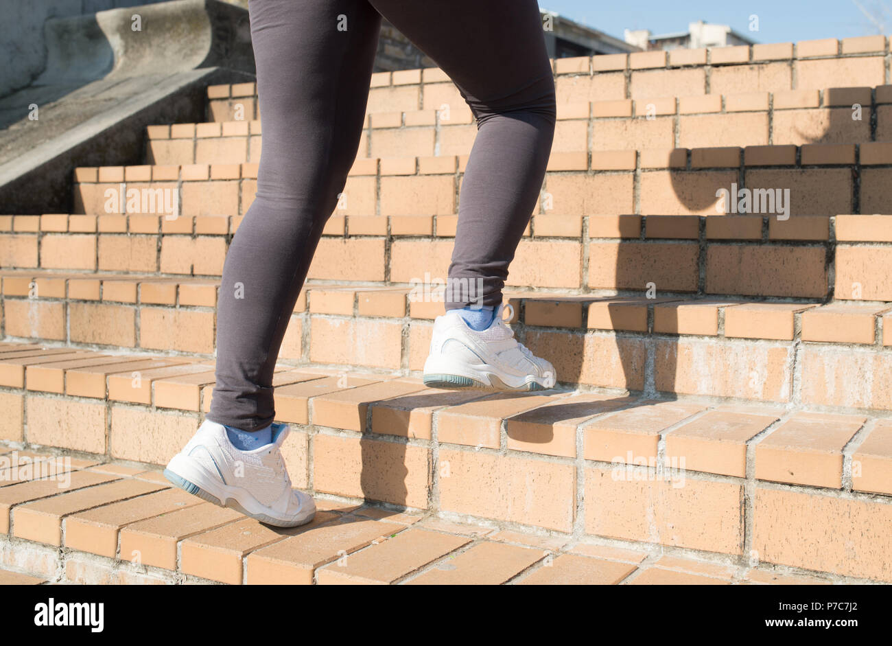 Runner feet running upstairs closeup on sneakers - woman fitness sunrise jog workout welness concept Stock Photo