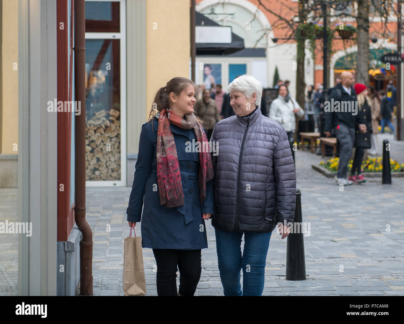 two woman, young and elderly walking on shopping street Stock Photo - Alamy
