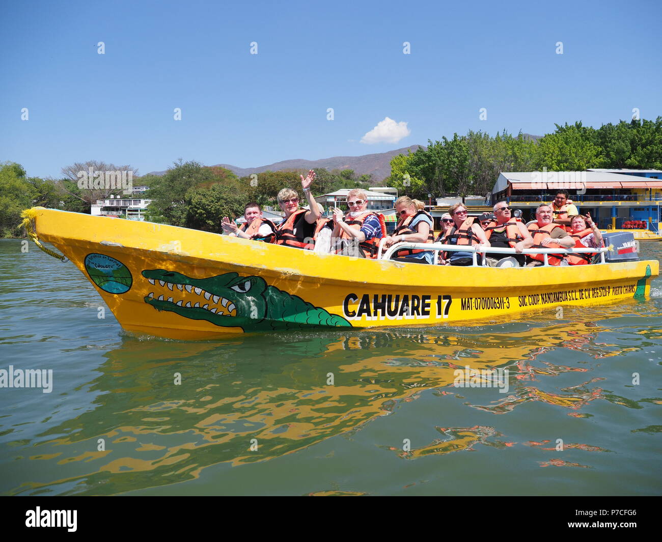TUXTLA, MEXICO on FEBRUARY 2018: Yellow motor boat with tourists, Grijalva river near Sumidero canyon, Chiapas State, blue sky in warm sunny day. Stock Photo