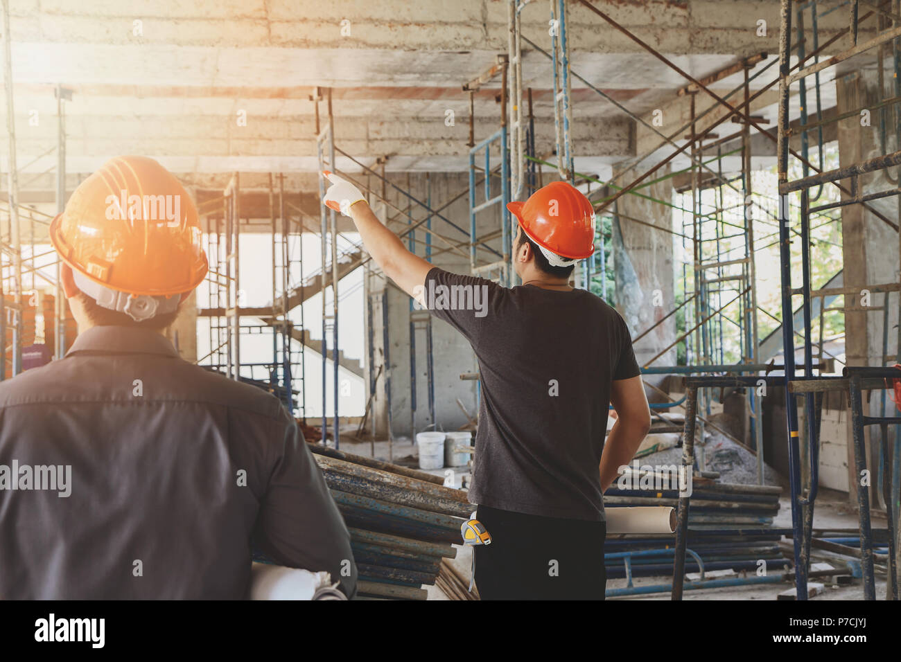 Engineer discussing with foreman about project in building construction site Stock Photo