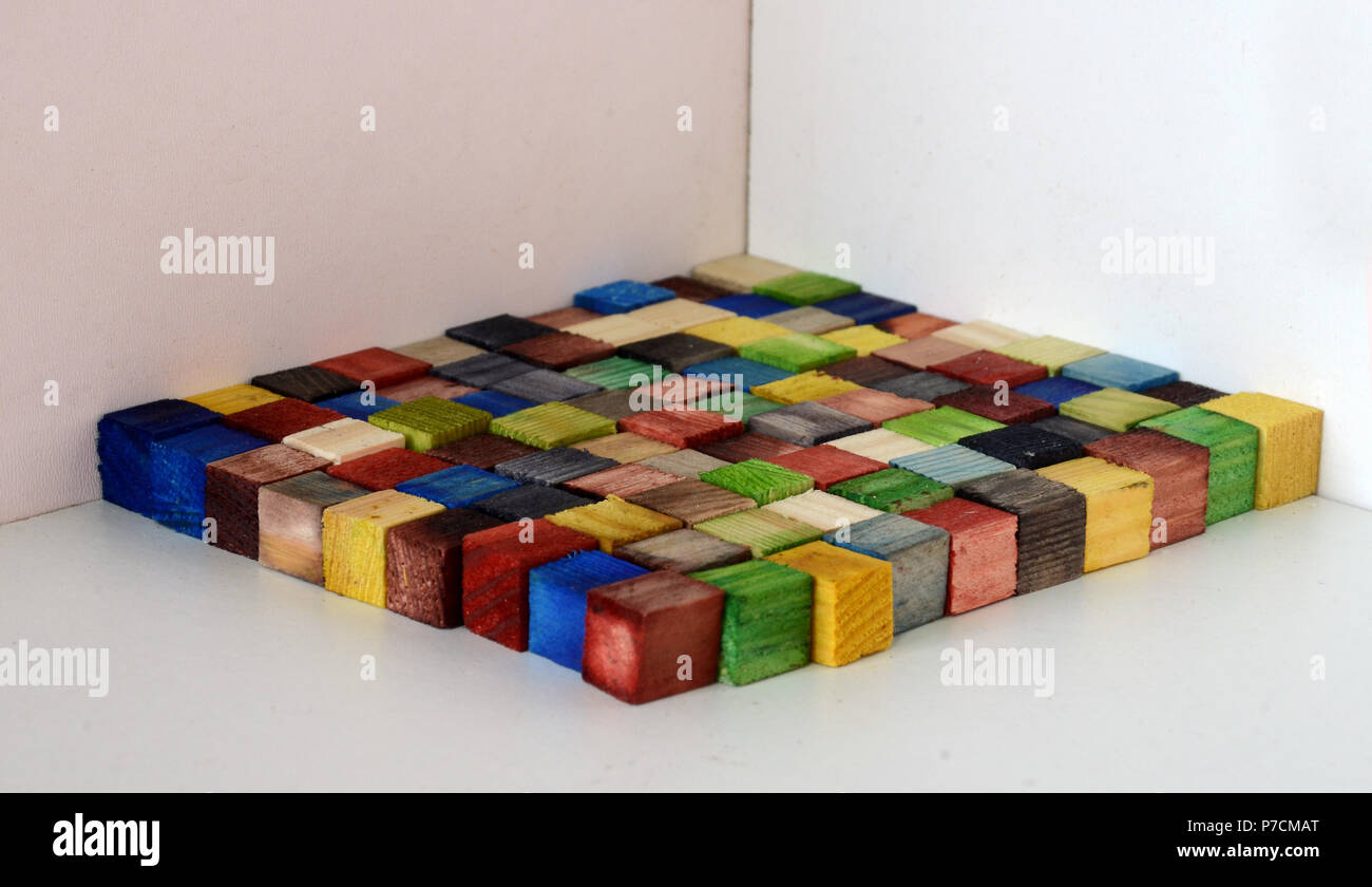 Surface made of colorful woodn bricks, each of a size of 1x1x1 cm, the surface consists of 100 of these cubes, so the upward floorage is 100 cm^2 Stock Photo