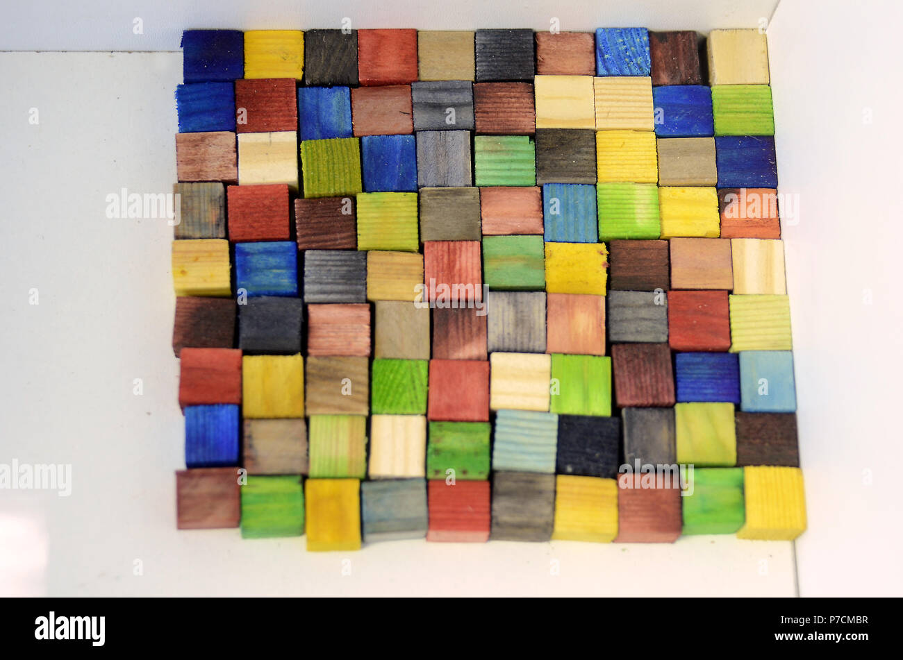 Surface made of colorful woodn bricks, each of a size of 1x1x1 cm, the surface consists of 100 of these cubes, so the upward floorage is 100 cm^2 Stock Photo