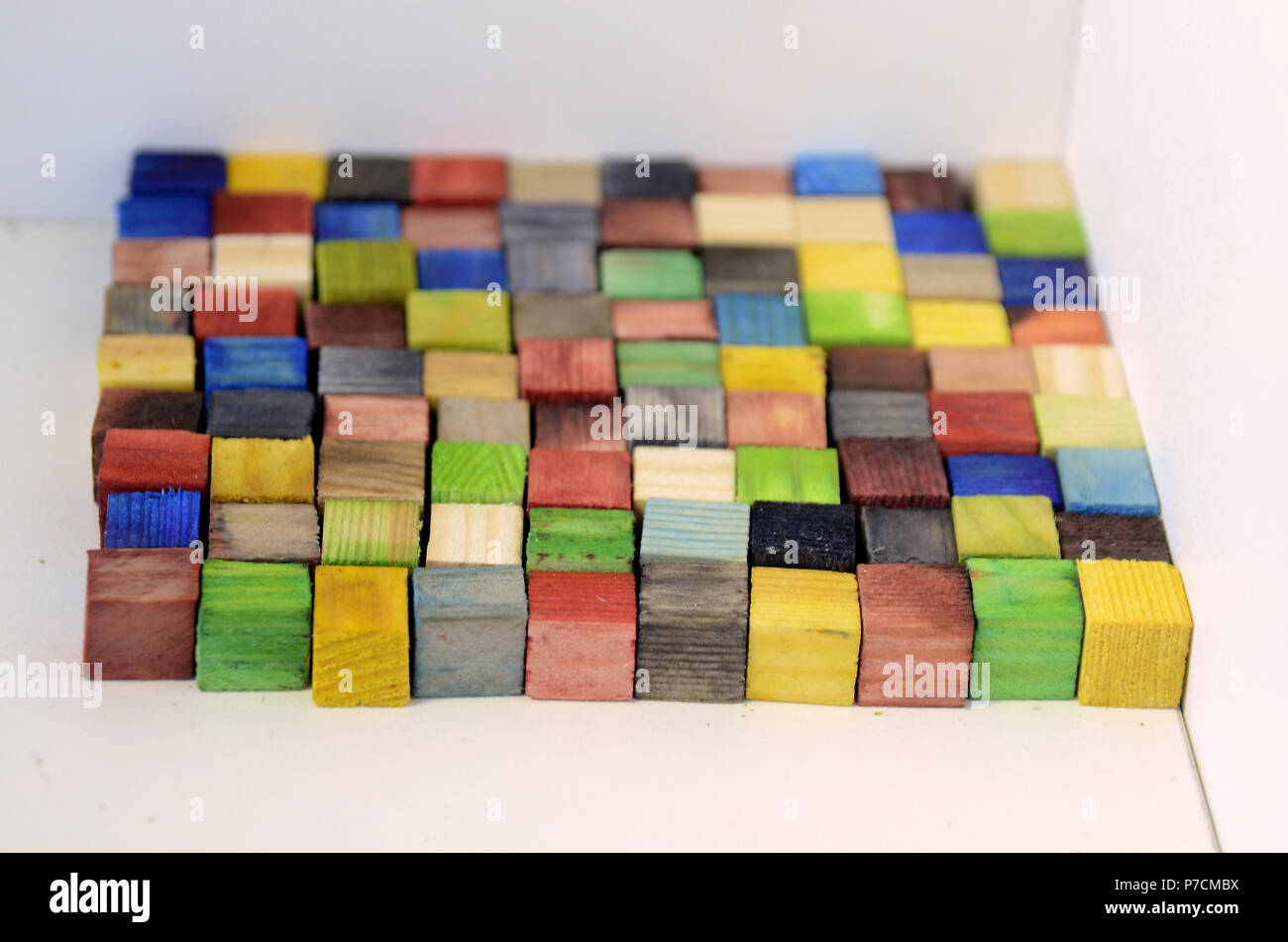 Surface made of colorful woodn bricks, each of a size of 1x1x1 cm, the surface consists of 100 of these cubes, so the upward floorage is 100 cm^2 Stock Photo