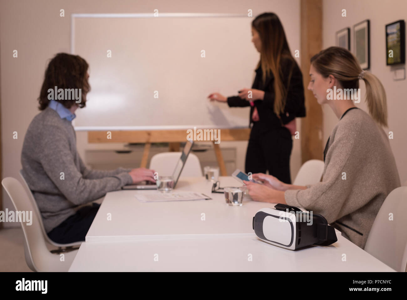Business colleagues discussing over white board in conference room Stock Photo