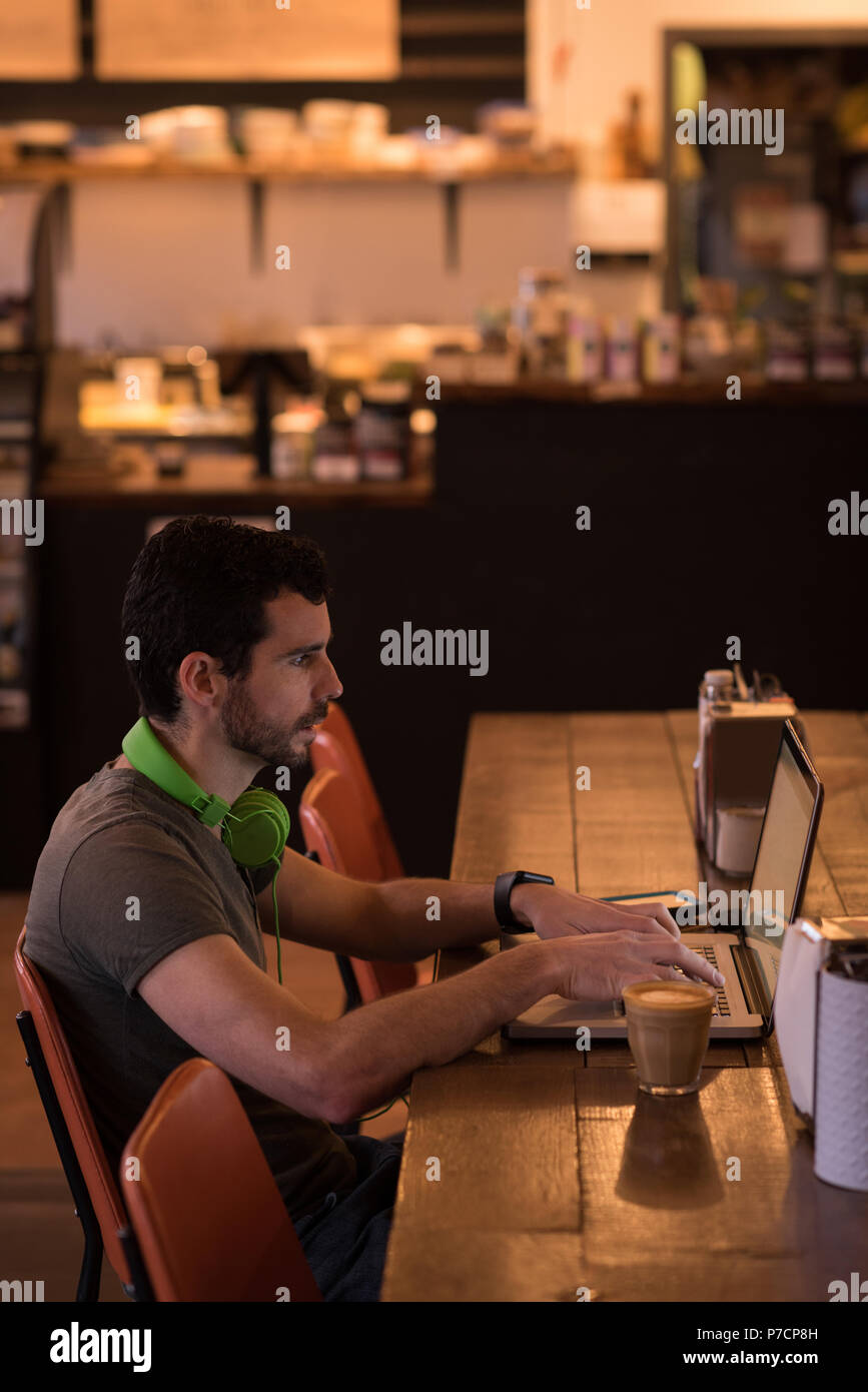 Man using laptop in cafe Stock Photo