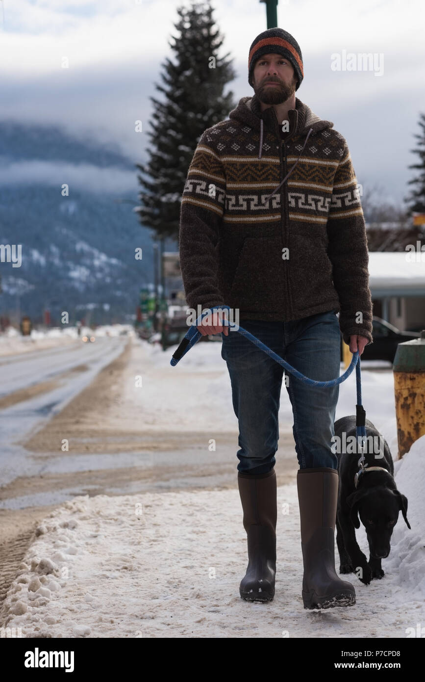 Man walking with his dog on sidewalk Stock Photo Alamy