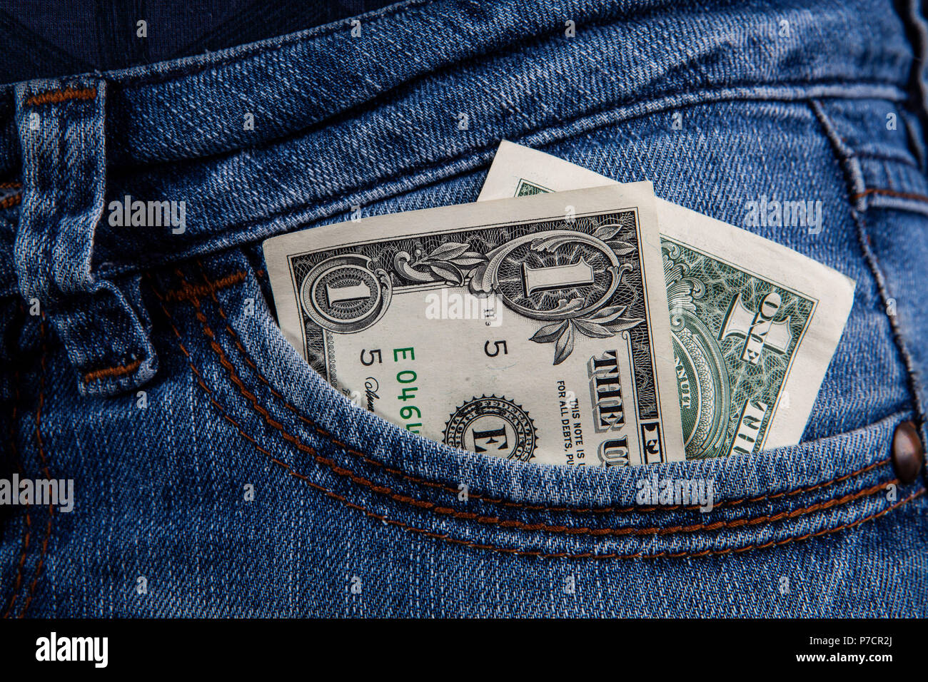 1 US dollar bill in front pocket of female blue jeans - minimum wage  concept Stock Photo - Alamy