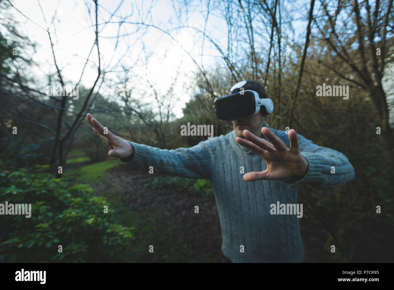 Man using virtual reality headset in forest Stock Photo