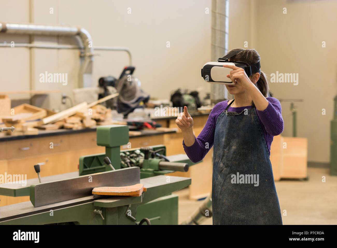 Female carpenter using virtual reality headset Stock Photo