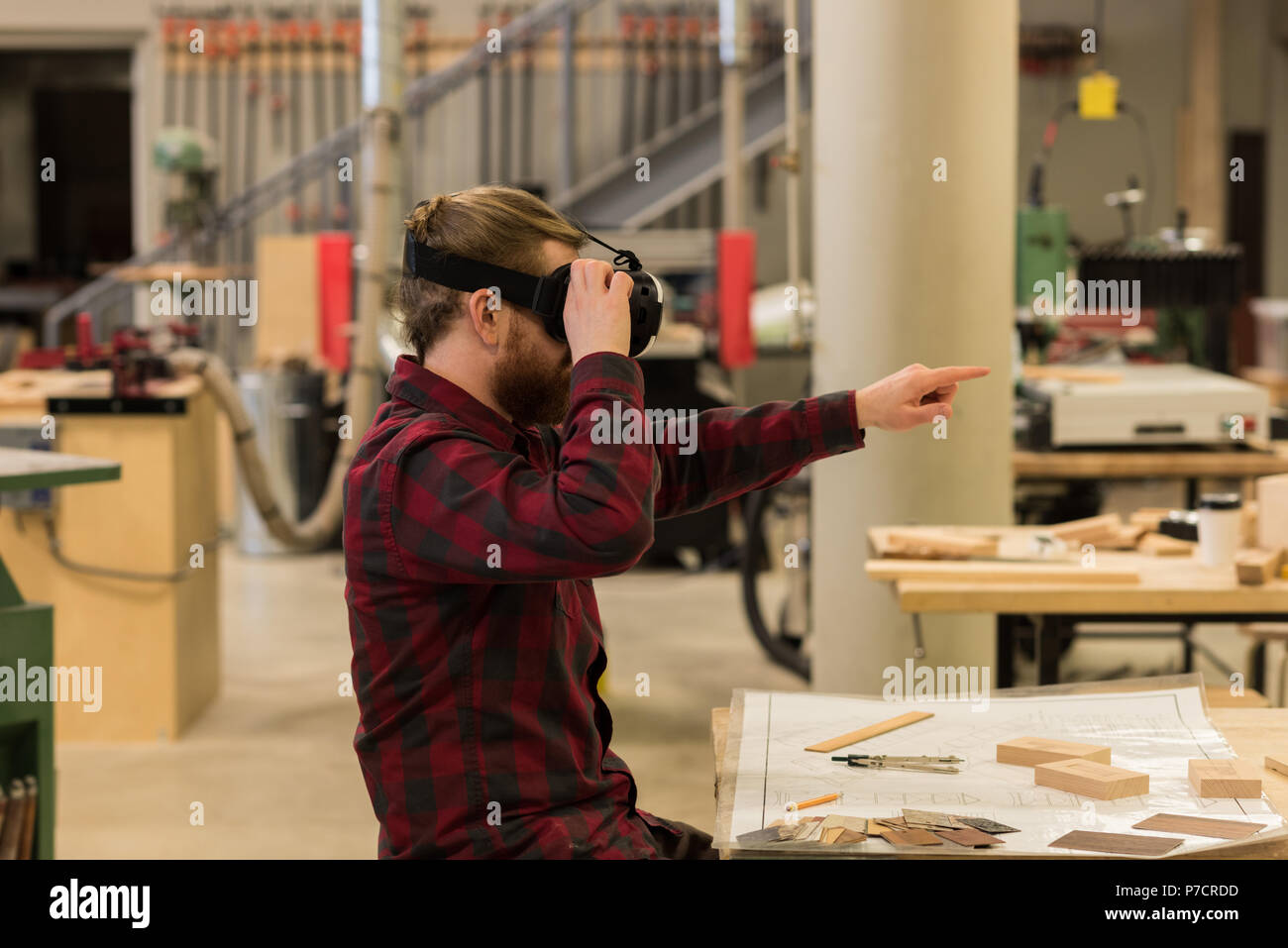 Male carpenter using virtual reality headset Stock Photo