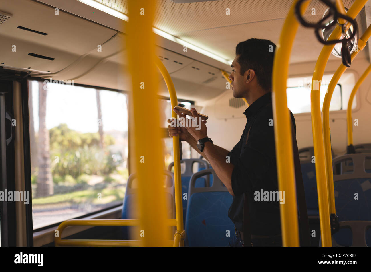 Businessman talking on mobile phone while travelling in bus Stock Photo