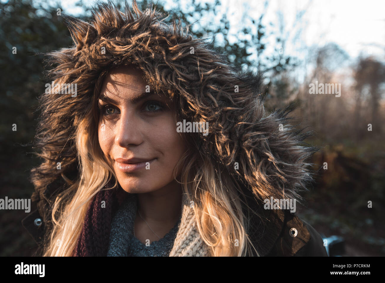 Woman in hoodie standing at forest Stock Photo