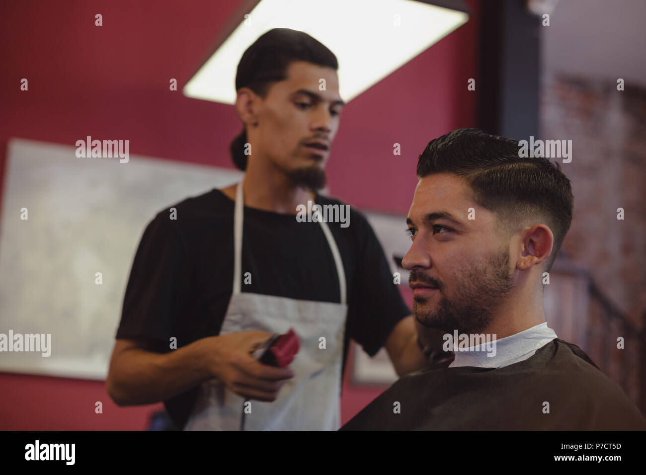 Man getting his hair trimmed with trimmer Stock Photo