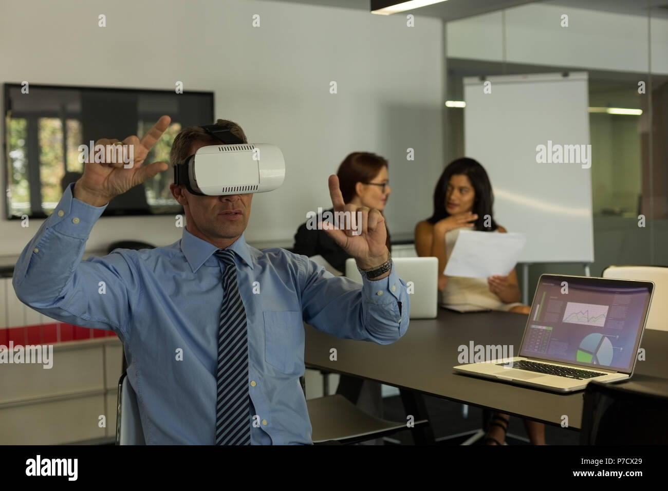 Businessman using virtual reality headset in conference room Stock Photo