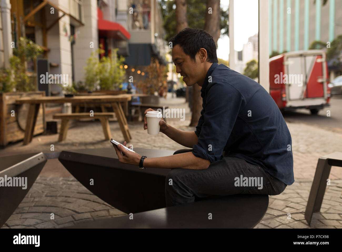 Businessman using mobile phone in the pavement cafe Stock Photo