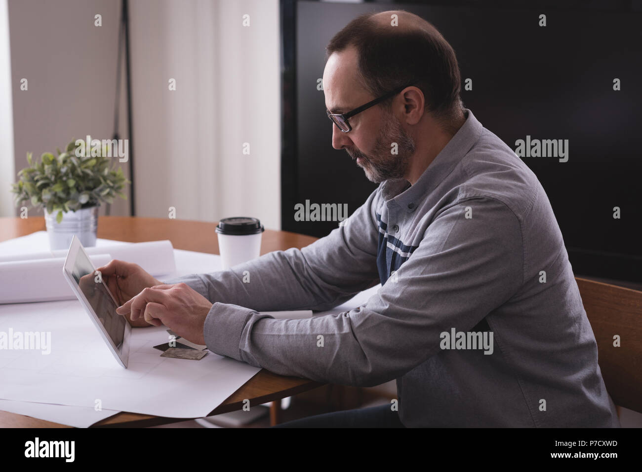 Male executive using digital tablet at desk Stock Photo