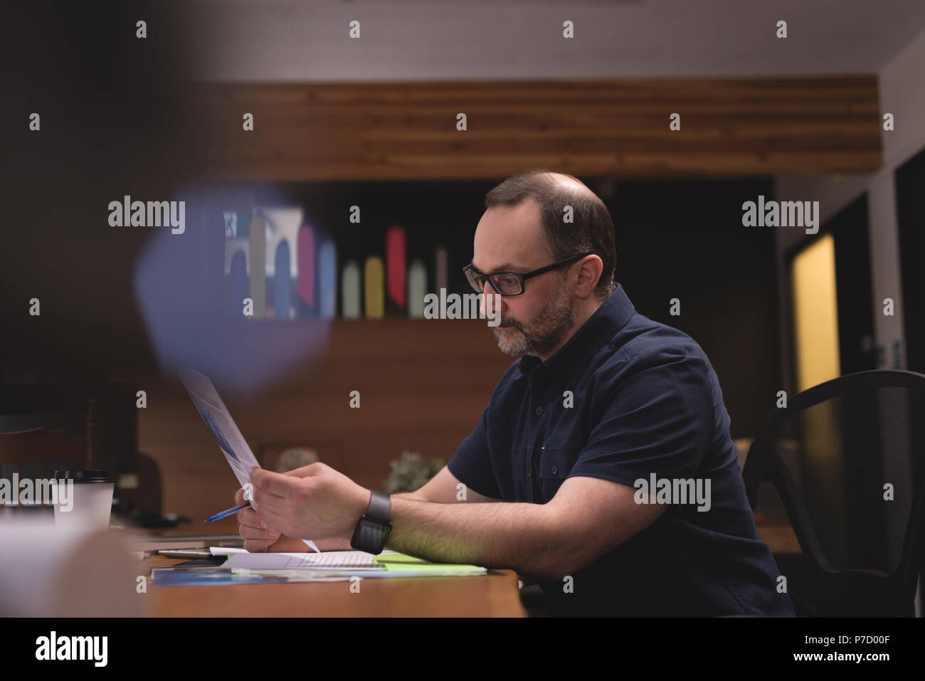 Male executive looking at graph document Stock Photo