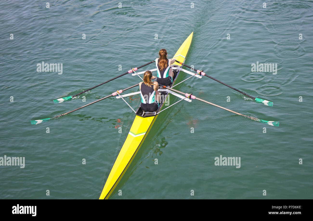 Two young women rowing race in lake Stock Photo