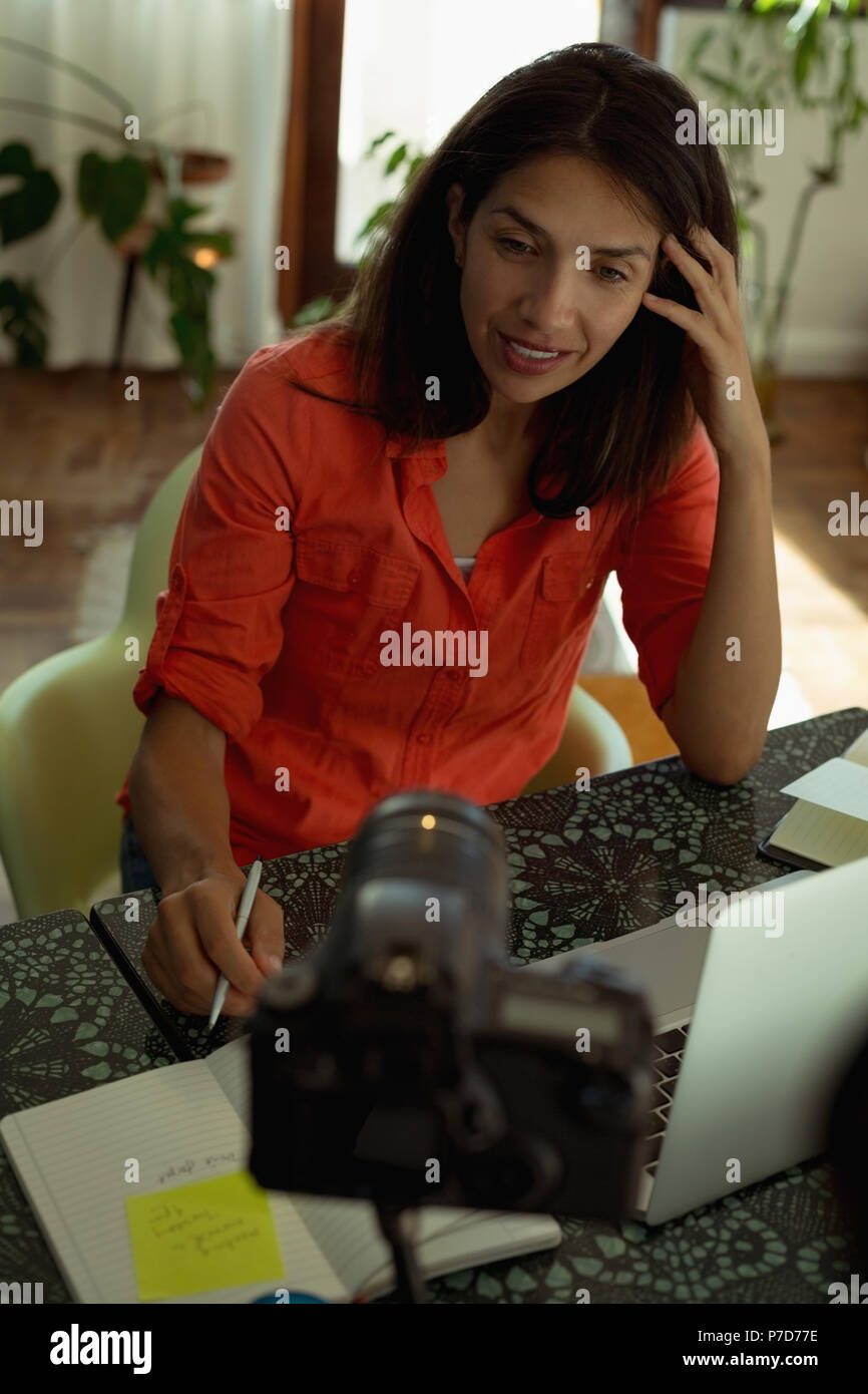 Female video blogger recording video vlog in living room Stock Photo