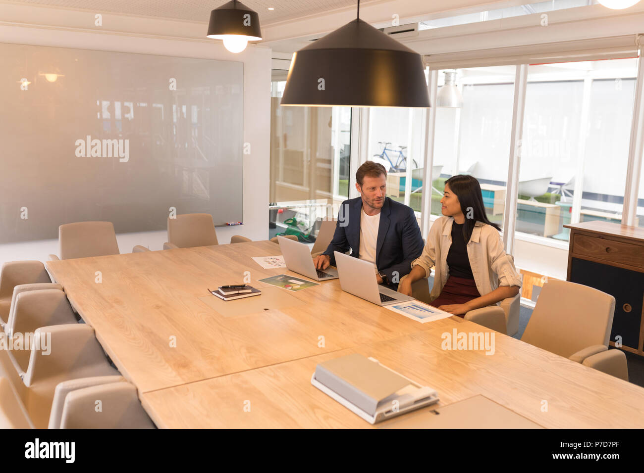 Business colleagues interacting with each other in conference room Stock Photo