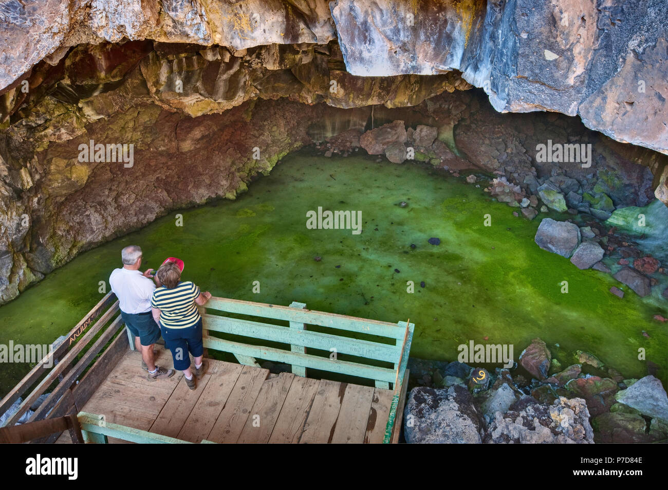 Tourists at frozen pool inside Ice Caves in summer, inside lava field at El Malpais National Monument, New Mexico, USA Stock Photo